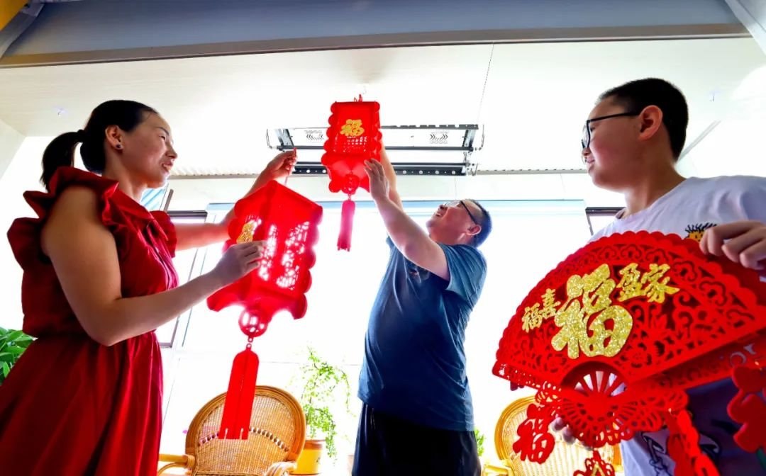 ↑2022年8月30日，甘肃省张掖市民乐县生态及地质灾害避险搬迁到乐民新城新居的一户人家在阳台上挂福字彩灯。2022年，该县全县域统筹、全链条发展、全要素保障，全力以赴推动生态及地质灾害避险搬迁工作各项任务落地见效，加快促进城乡融合发展、均衡发展。