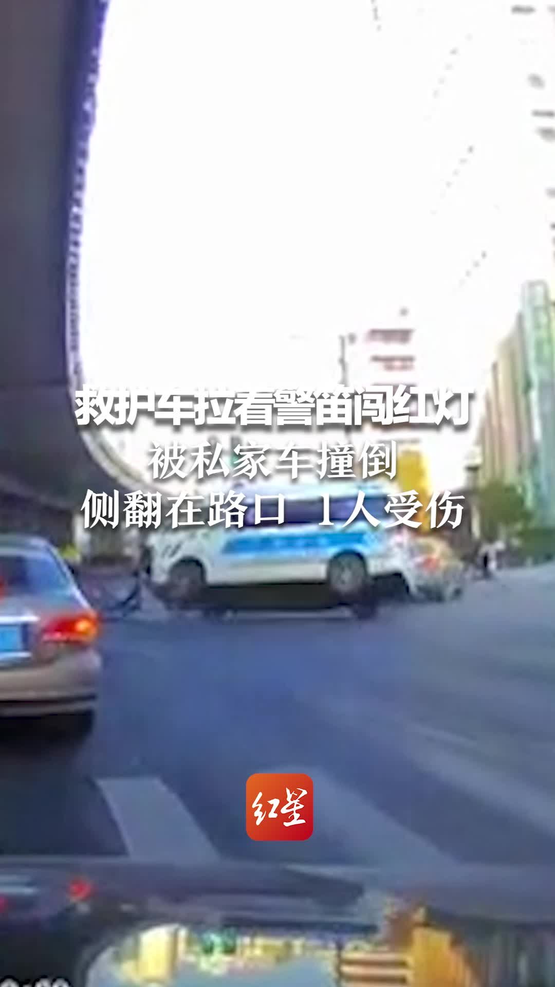 上海一辆救护车拉着警笛闯红灯，被一辆私家车撞倒，侧翻在路口