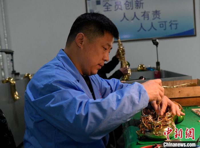 12月30日，张磊在组装萨克斯。贾枭梦 摄