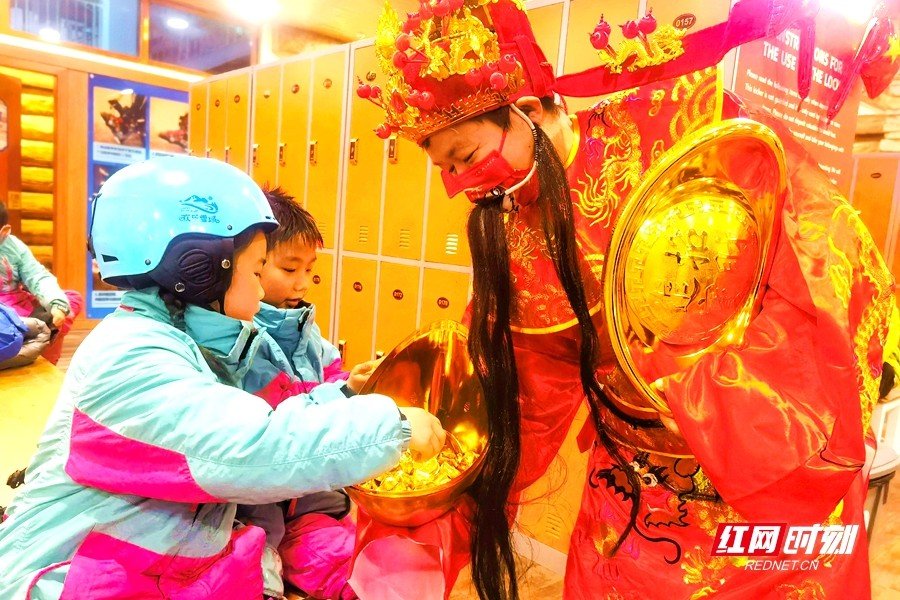 湘江欢乐城·欢乐雪域,财神送“金币”。当天,景区游客接待量恢复至去年同期8成。