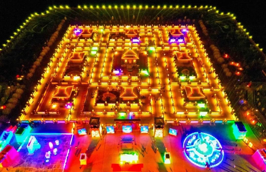 ↑2022年2月4日晚，农历正月初四，甘肃省张掖市甘州区碱滩镇屋兰古镇内，游客观赏规模宏大的非物质文化遗产九曲黄河灯阵。（无人机航拍）