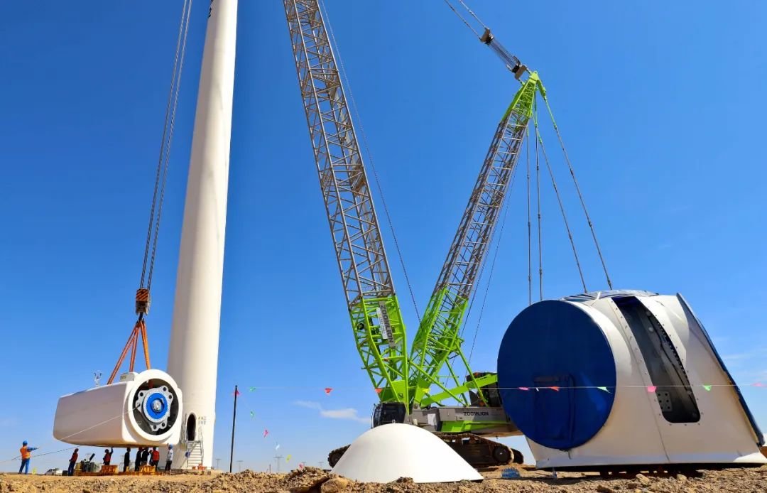 ↑2022年9月7日，在甘肃省张掖市高台县北部滩500兆瓦风电基地风力发电机主机吊装作业现场。连日来，该基地加紧调试、吊装和安装94台风力发电机组，确保实现年底并网发电。
