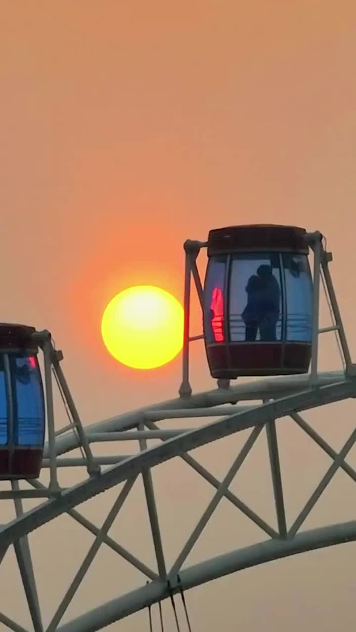 浪漫！摄影师拍到夕阳下情侣在摩天轮中相拥