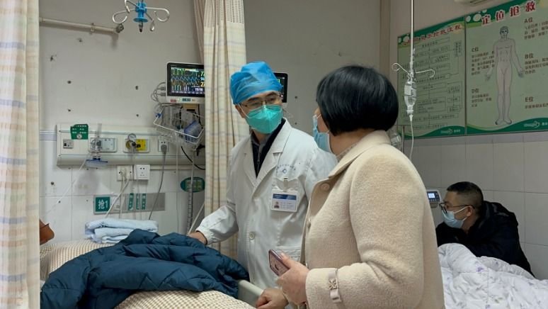 2022年12月31日深夜，孙传政（左）在急诊抢救室和患者家属沟通。（受访者供图）