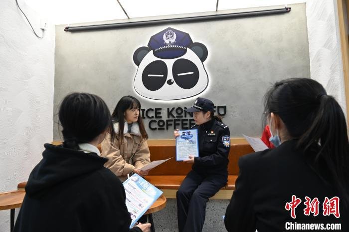 民警在咖啡店进行反诈知识宣传。　安源 摄