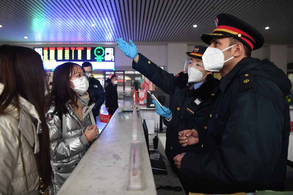 1月13日，弗兰克（右一）在天水南站候车大厅旅客服务台和工作人员王丽一起回答旅客问询。新华社记者 陈斌 摄