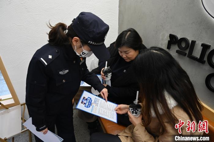 民警在咖啡店进行反诈知识宣传。　安源 摄