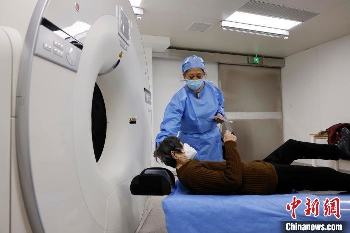 医护人员在CT扫描室帮助市民进行拍片。　殷立勤 摄