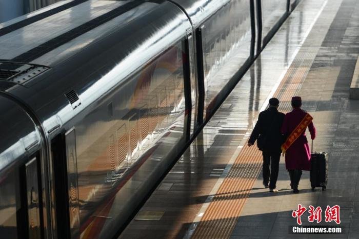 1月7日，乘务员在重庆北站站台帮助老人乘车。当日，2023年春运正式启幕。 中新社记者 何蓬磊 摄