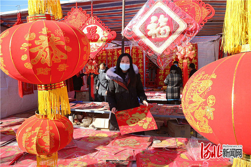 图2：市民在迁安市兴安街道万嘉春节饰品年货市场选购福字。.jpg