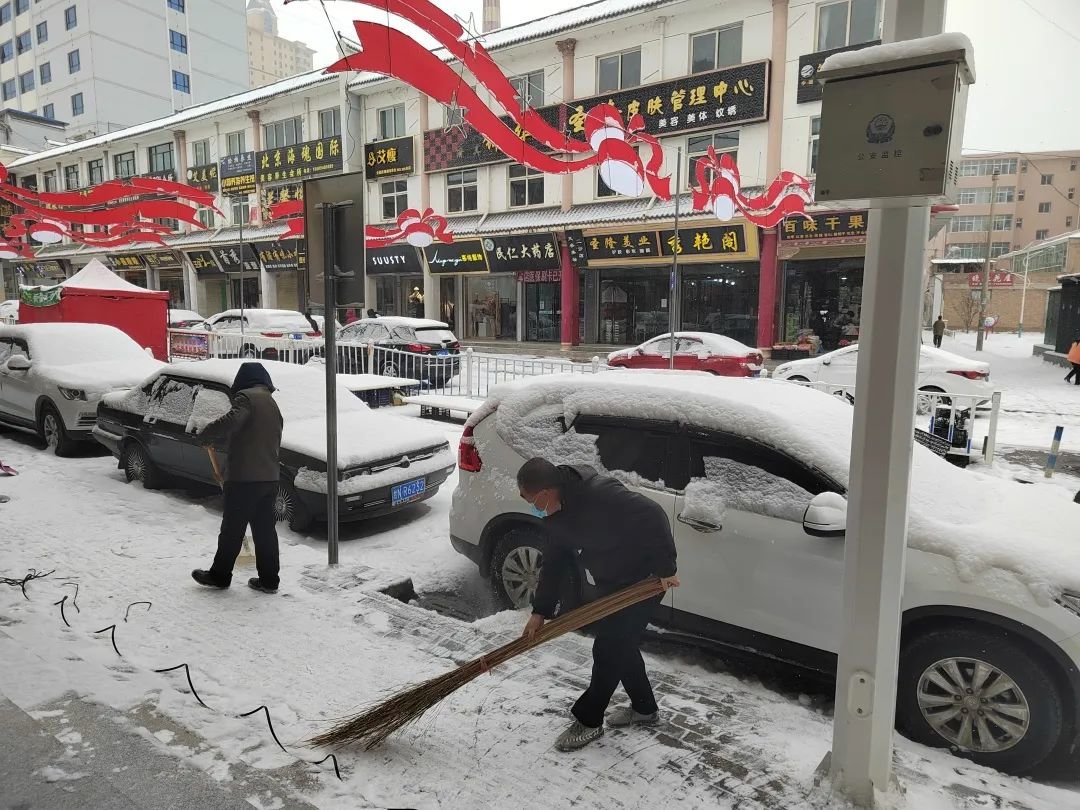 13日凌晨,康乐出现降雪天气,市民清扫道路积雪。(图:李娟)