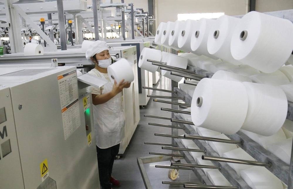 日前，在奉新县高新技术产业园江西金源纺织有限公司生产车间，工人正在生产线上忙碌。 （邓建刚 余辉辉 摄）