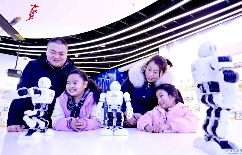 2023年1月24日，位于甘肃省张掖市临泽县的张掖科技馆内，家长同小朋友一起观看机器人表演舞蹈。