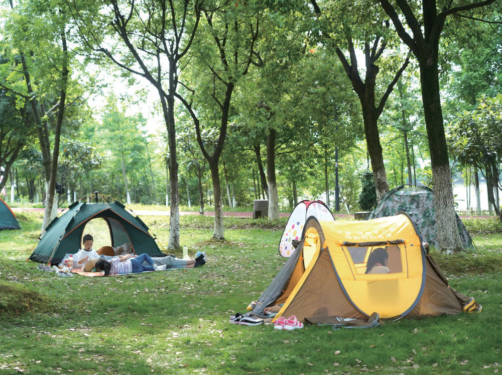 市民在南昌市艾溪湖湿地公园的草地上露营休憩 (万象/摄)