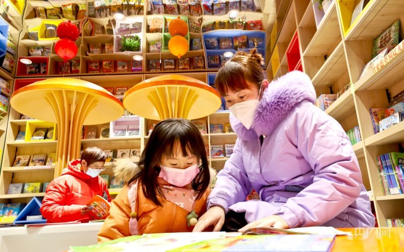 1月23日，一位母亲带着孩子在甘肃张掖锦华书城读书。（央广网发 王将 摄）