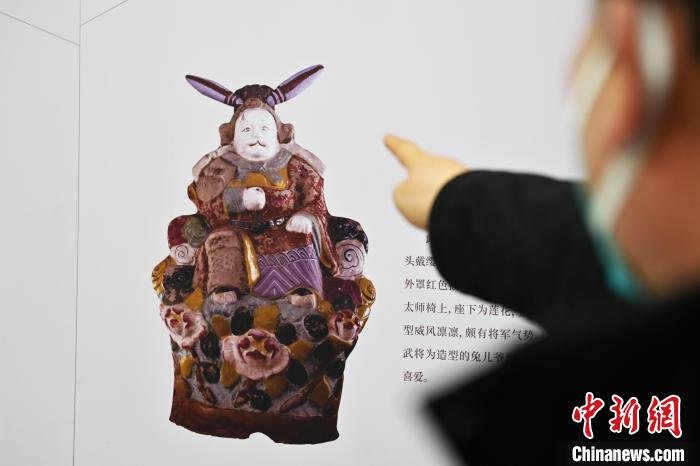 图为1月25日，甘肃省博物馆内，游客正在参观故宫博物院的泥制兔儿爷文物图。　李亚龙 摄