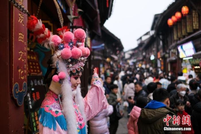 图为1月26日，重庆磁器口古镇，一川剧表演者正在招揽客人。 中新社记者 何蓬磊 摄