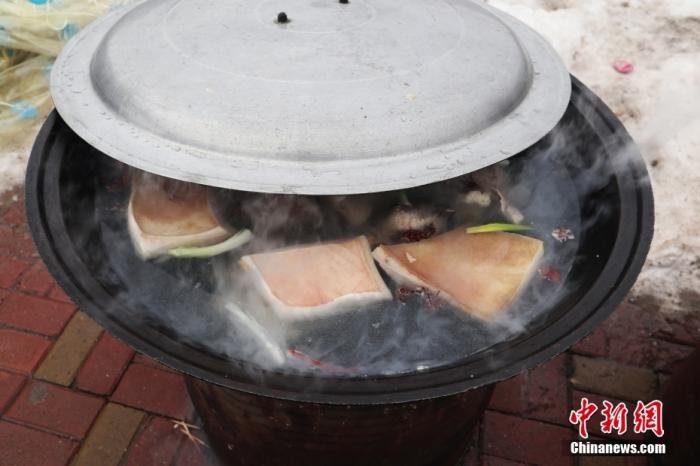图为1月13日，吉林舒兰，大锅内在煮年猪肉。 中新社记者 苍雁 摄