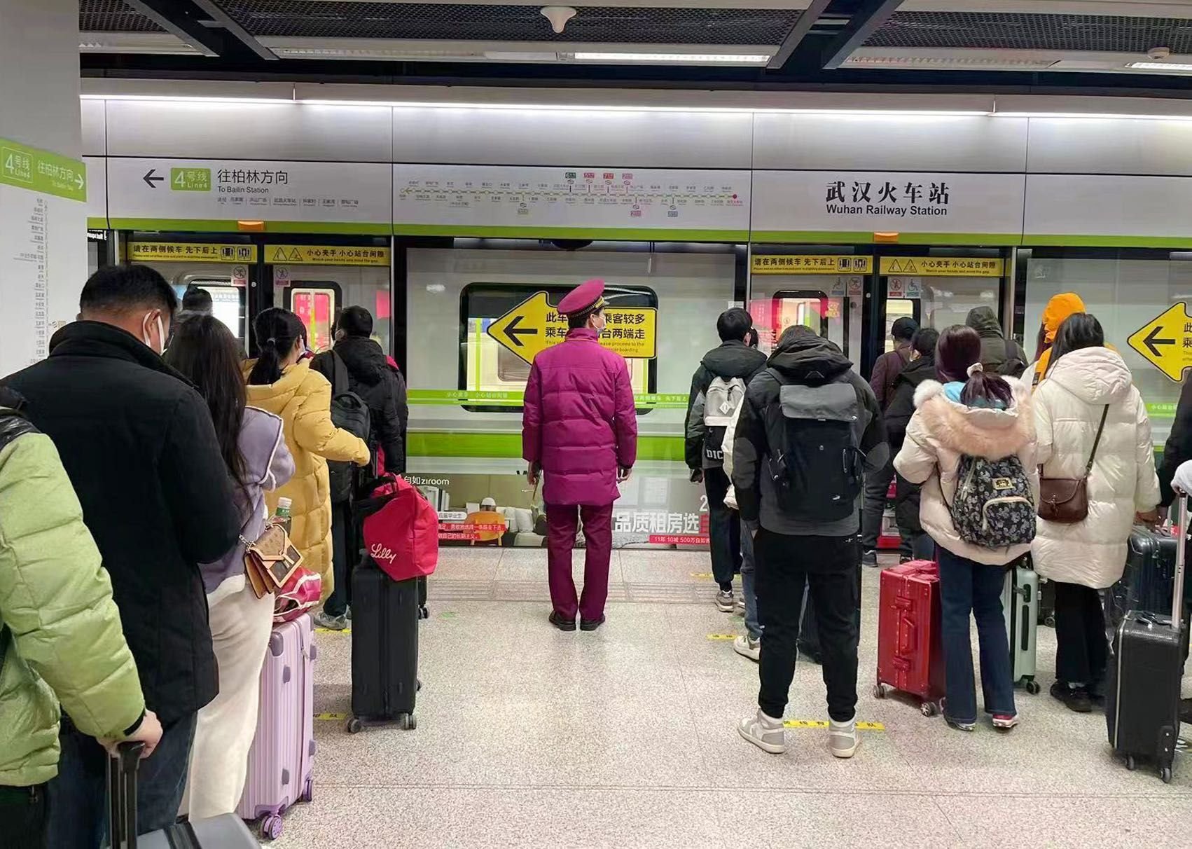 地铁4号线武汉火车站工作人员疏导乘客有序乘坐电梯