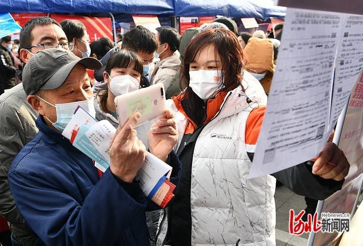 2月2日，在河北省石家庄市栾城区春风行动暨就业援助月招聘会现场，求职者用手机拍摄企业招聘信息。