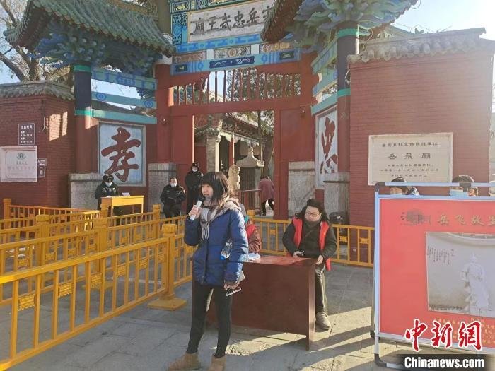 资料图：图为一名游客在岳飞纪念馆门前背诵《满江红》。靳晓晶 摄
