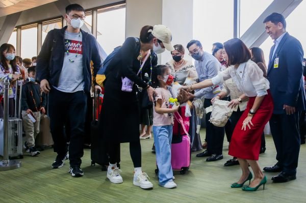 1月24日，菲律宾旅游部在马尼拉国际机场安排了特色民乐表演，热烈欢迎中国游客到来。图为菲律宾旅游部长克里斯蒂娜·弗拉斯科（前右二）为中国游客送上伴手礼。（乌马利 摄）