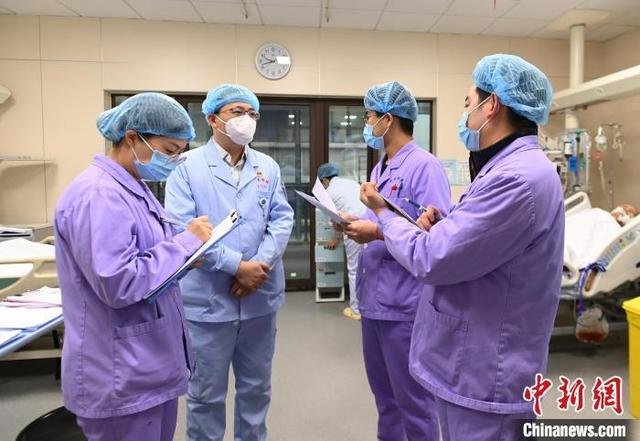 资料图:医护人员在交流病人病情 安源 摄