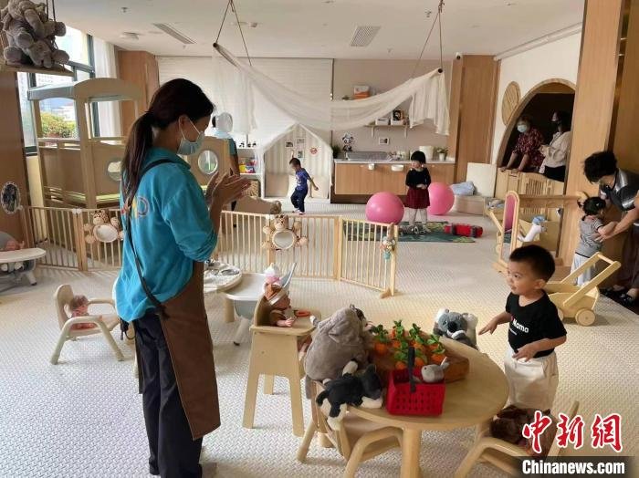 资料图：社区“宝宝屋”里，专业育儿师带着孩子做游戏。江宁路街道供图