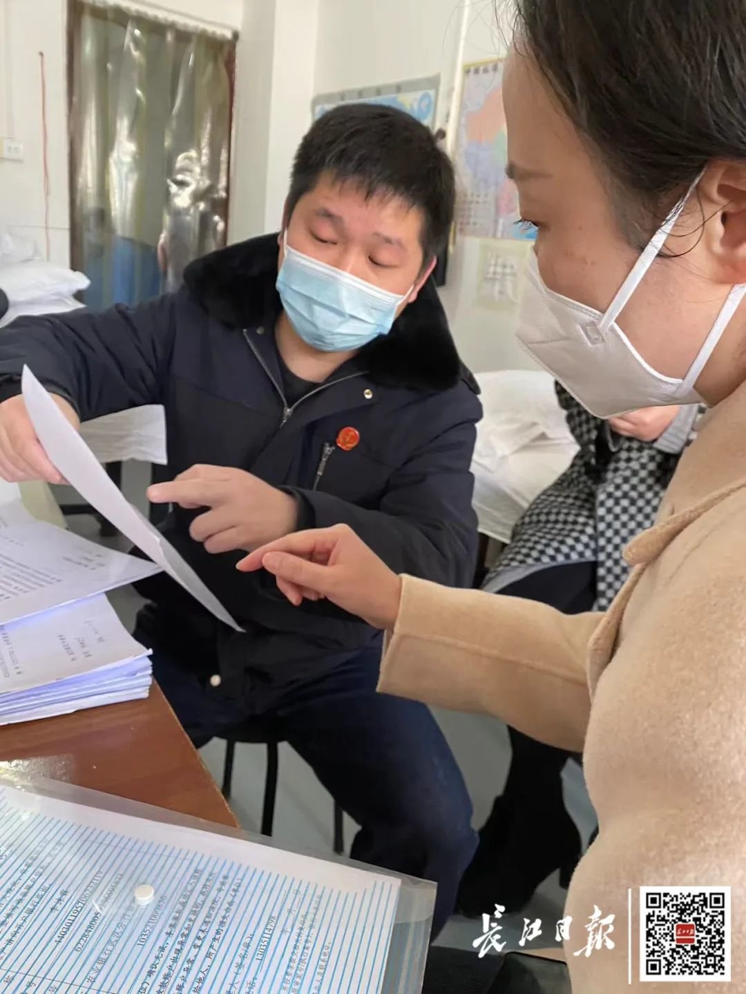 丁小雨（左一）给代理律师展示法律文书。记者耿珊珊 摄