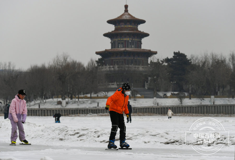 在飘飞的雪花当中，市民尽享冰雪的乐趣。