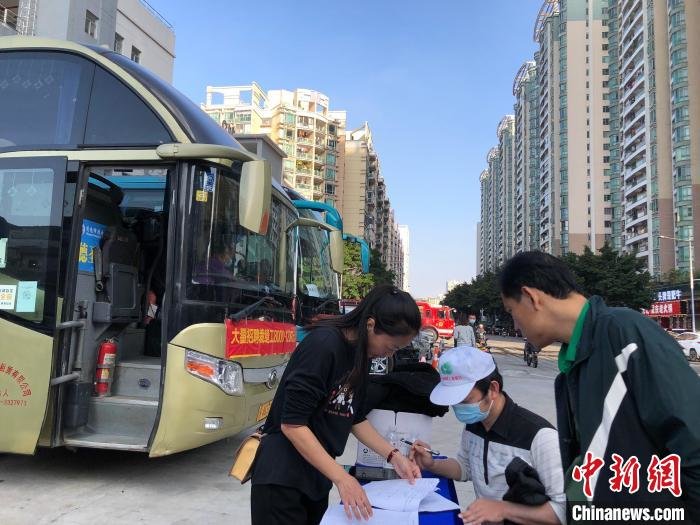 图为工人正在报名填表，准备坐大巴参观广清纺织服装转移产业园 孙秋霞 摄