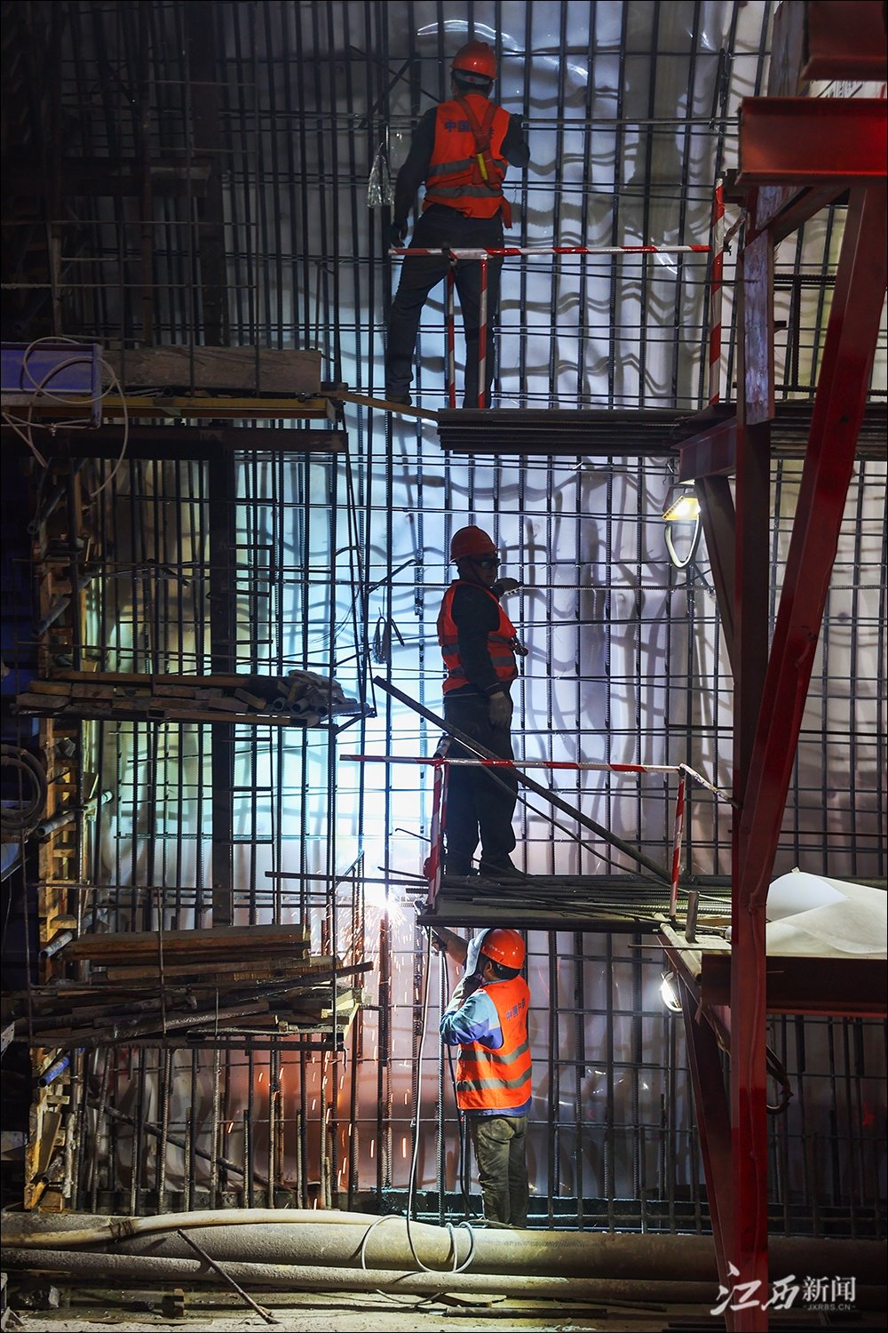 ▲南昌绕城高速公路西二环梅岭隧道内，工人们在焊接钢筋。