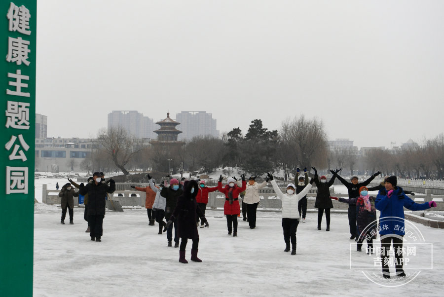 公园里锻炼的叔叔阿姨，在雪地里翩翩起舞，各色的羽绒服和白雪相映成趣。
