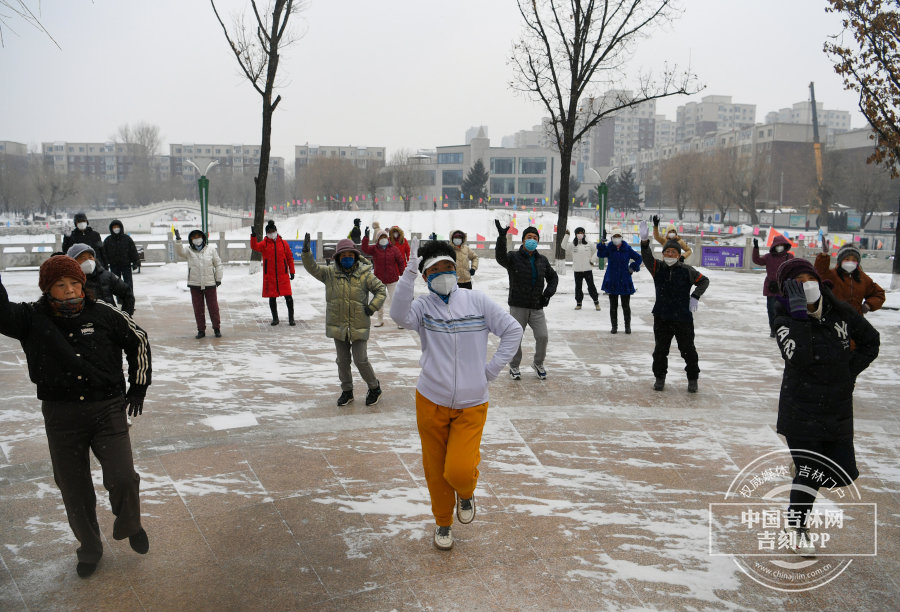 公园里锻炼的叔叔阿姨，在雪地里翩翩起舞，各色的羽绒服和白雪相映成趣。