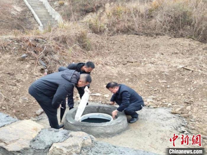 溆浦县技术人员查看水源池建设。　彭丽丽 摄