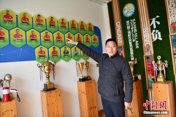 图为三河村农民健身足球俱乐部内展示的球员照片和奖杯。(2022年12月28日摄) 中新社记者 张浪 摄