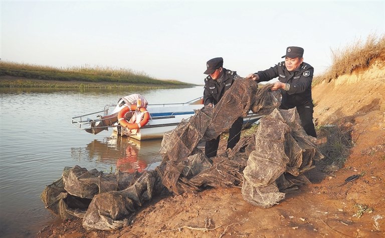 2022年12月14日,位于南昌市新建区的鄱阳湖南矶湿地,护渔队队员在处理湖边残留渔具,给候鸟提供食物充足、生活安全的环境。