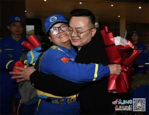 女队员罗旭的儿子为母亲送上鲜花 记者王祺 摄