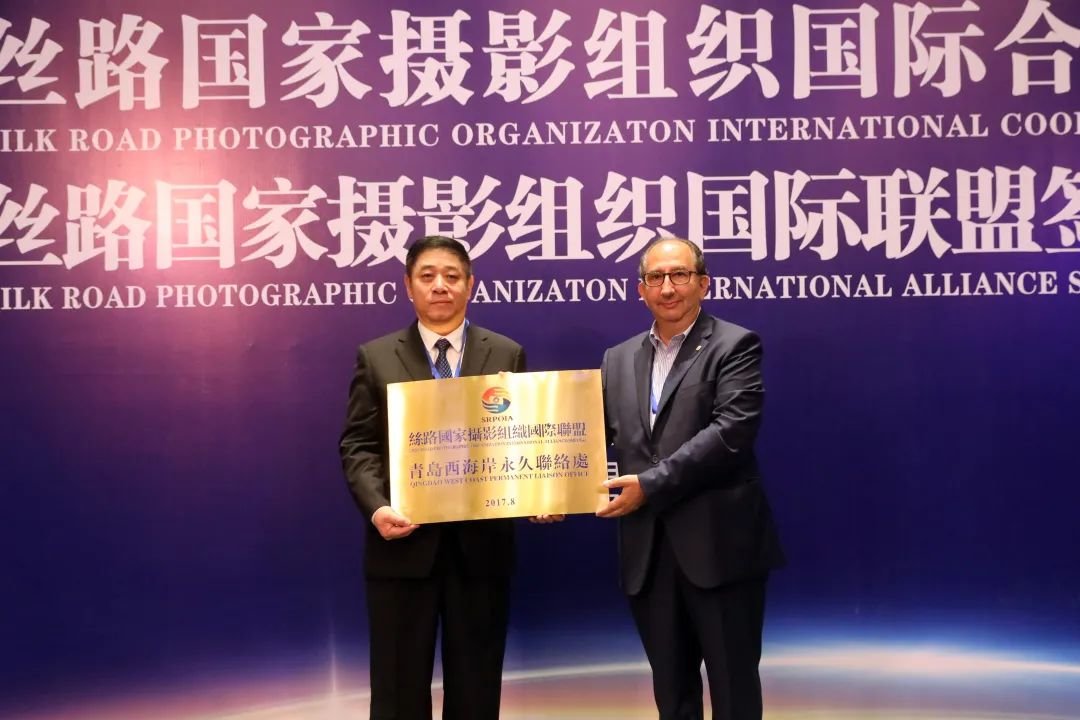 丝路国家摄影组织国际联盟名誉主席里卡尔多&middot;布西向青岛西海岸西区授予“丝路国家摄影组织国际联盟青岛西海岸永久联络处”匾牌