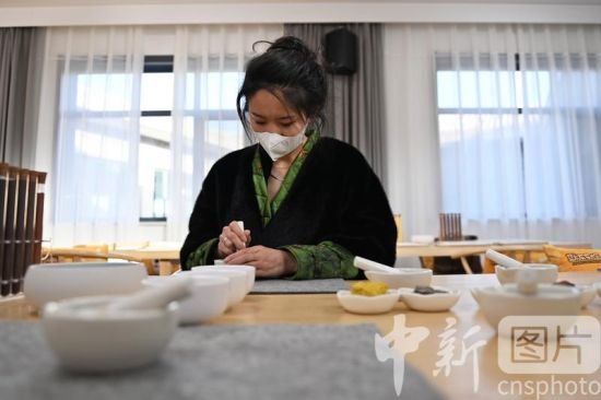 2月16日，甘肃敦煌“莫高学堂”内，游客正在体验矿物质颜料的古法研制。