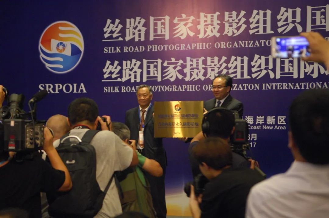 丝路国家摄影组织国际联盟主席杨元惺向青岛西海岸西区授予“丝路国家摄影组织国际联盟青岛西海岸永久摄影基地”匾牌