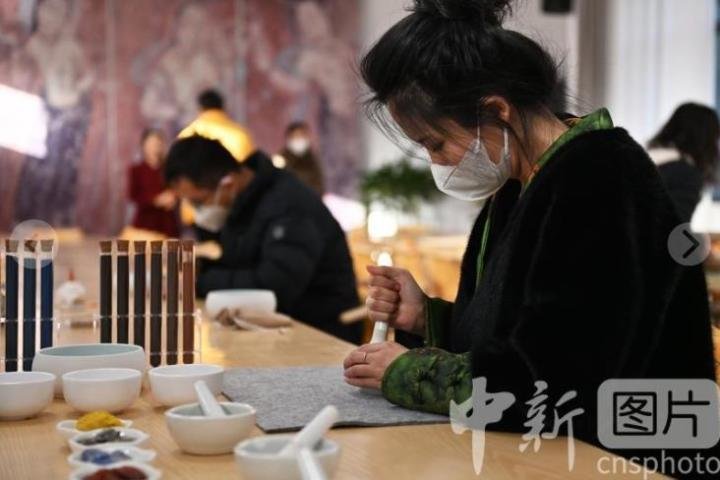 2月16日，甘肃敦煌“莫高学堂”内，游客正在体验矿物质颜料古法研制技艺。