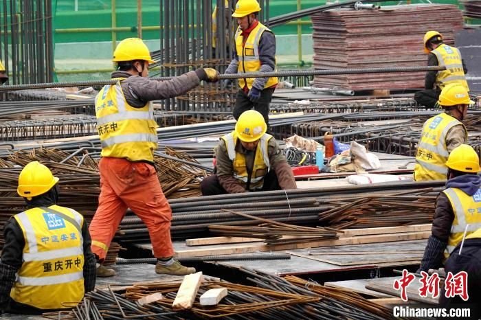 西安咸阳国际机场三期扩建工程1号能源站工地上，工人们正在捆扎、搬运钢筋。　张远 摄