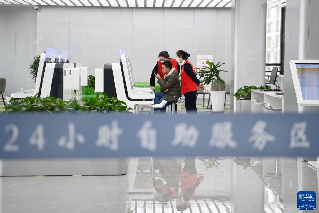 在武威市政府政务服务中心24小时自助服务区，志愿者引导市民办理业务（2月17日摄）。新华社记者 范培珅 摄