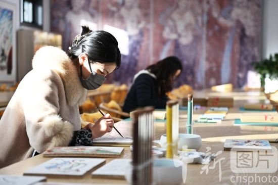 2月16日，甘肃敦煌“莫高学堂”内，游客正在绘制敦煌壁画。