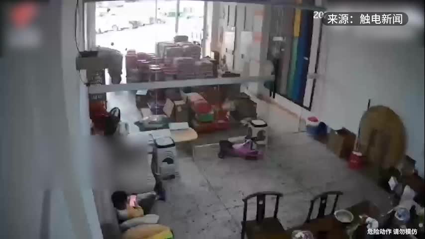 地震时男子一把提起幼儿脚往外跑