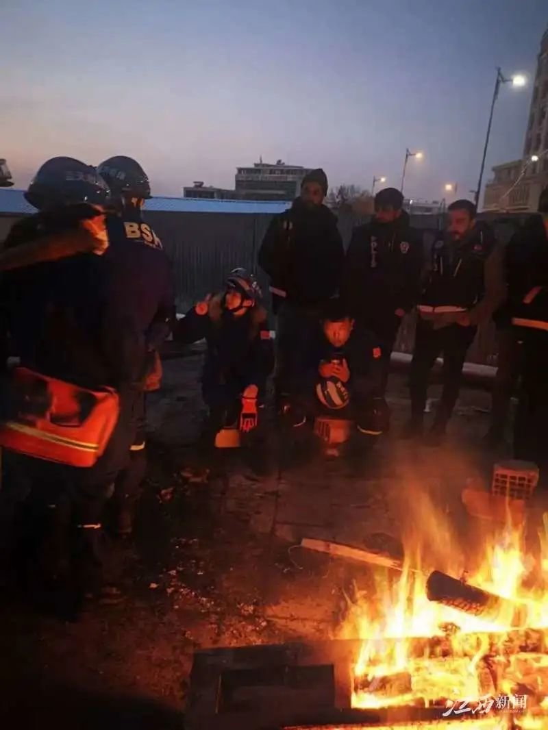 ▲江西救援队和土耳其当地人员一起烤火取暖。 以上图片由罗旭发自土耳其