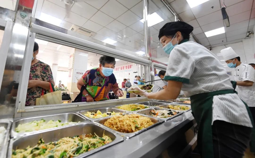 在瑶海区和平路街道社区大食堂,老人正在打饭。郭如琦 摄