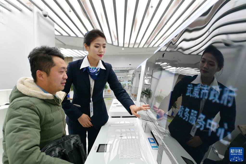 在武威市政府政务服务中心24小时自助服务区，工作人员（右）引导市民办理业务（2月17日摄）。新华社记者 范培珅 摄