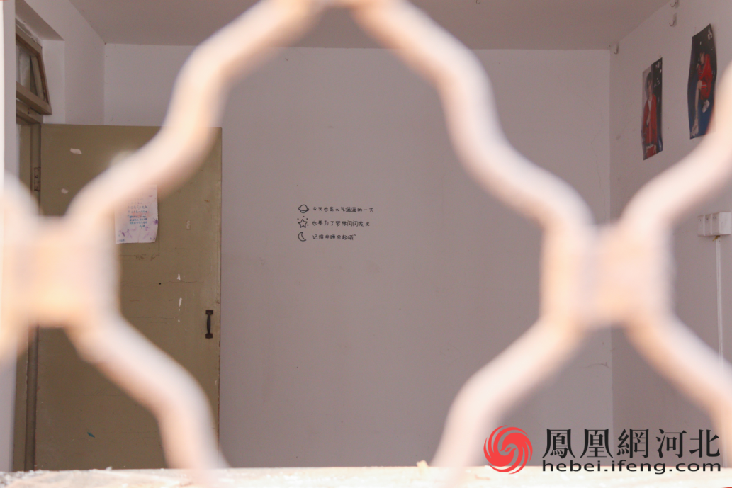 在宿舍楼里面，透过防护栏可以看到仍保留着学生们贴的海报。 李卓然/摄